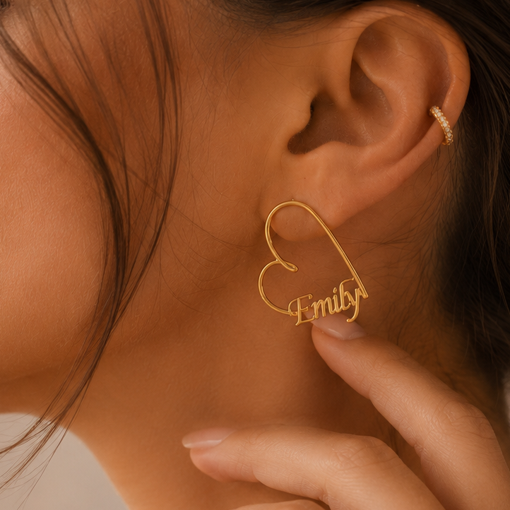 Close-up of personalised Heart-Shaped Name Earrings in solid 18K yellow gold featuring a custom name design.