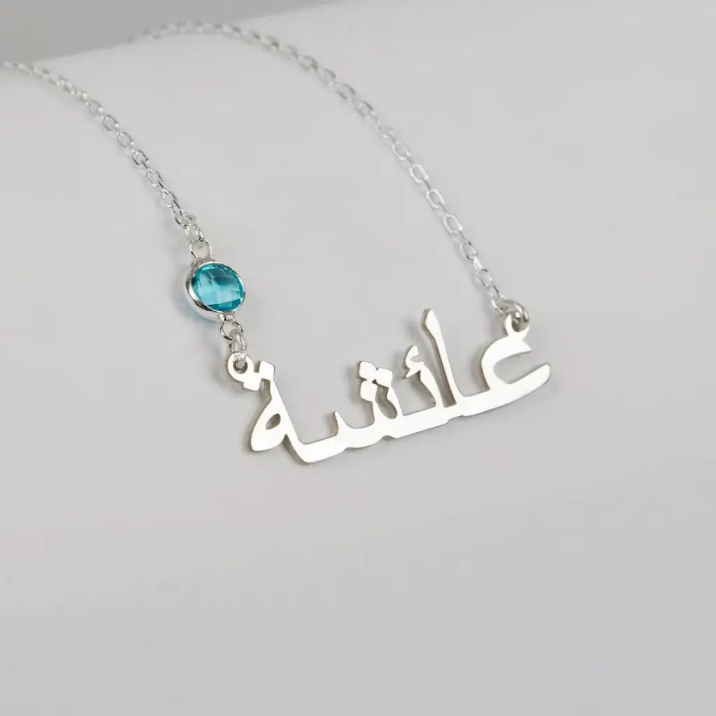 Simple yet eye-catching, this gold Arabic name necklace with birthstone is a stylish look anyone will appreciate. Our Name Necklace is a great piece that follows the fashion trend! Its fine curves and magnificent lettering make it a truly enjoyable necklace for you and your loved ones. Made in Dubai, UAE.