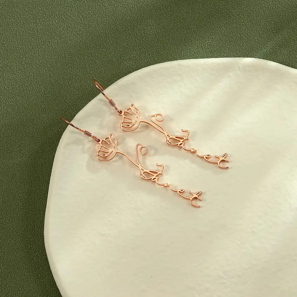 Birth flower name earrings made in real gold. Designed and handcrafted in the UAE. These gorgeous elegant birth flower name earrings are locally handcrafted with the highest quality materials and artisans available in Dubai.