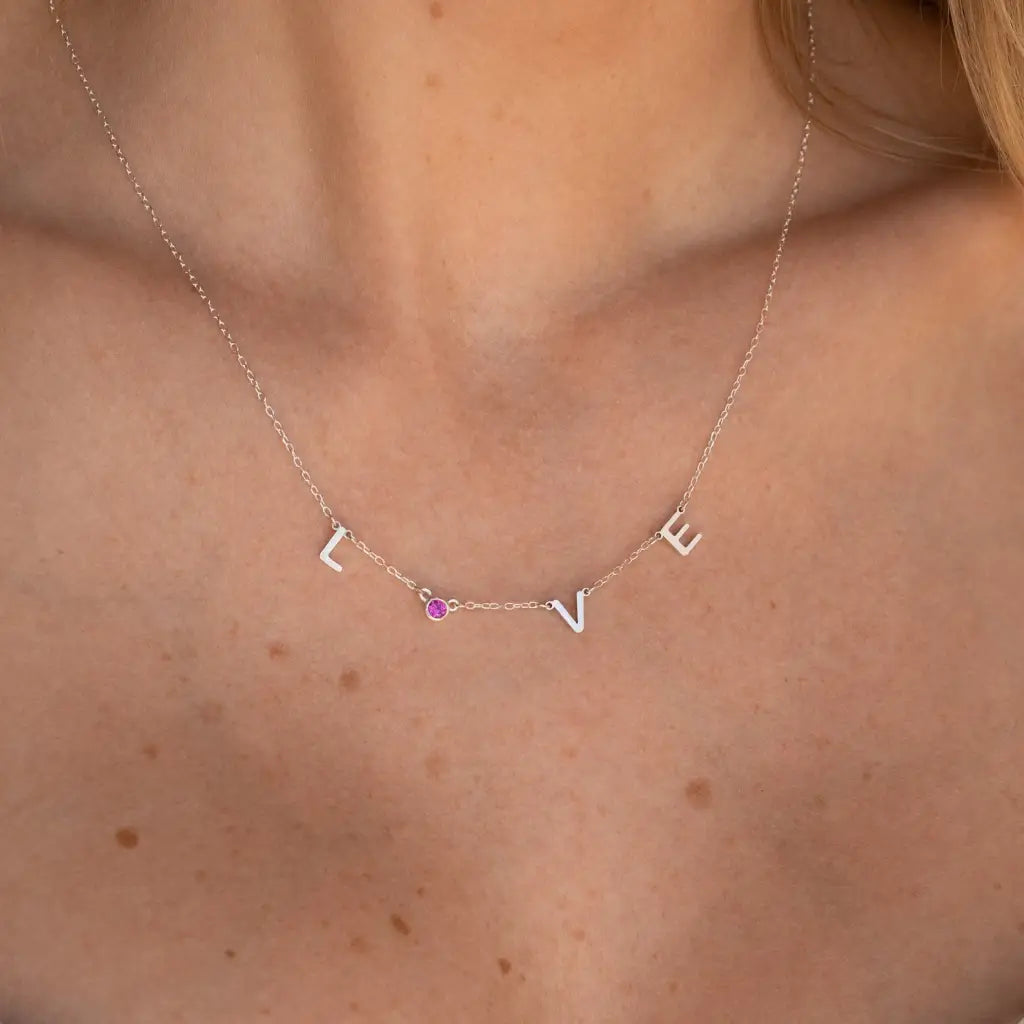 Our distinctive Birthstone Name Necklace is ethically crafted in real genuine gold by our skilled jewelers in Dubai. A truly lovely gift. Your loved one's name in gold, enhanced with their birthstone, creating a uniquely, personal gift. Gift a memory keeper for life. Designed in the United Arab Emirates.