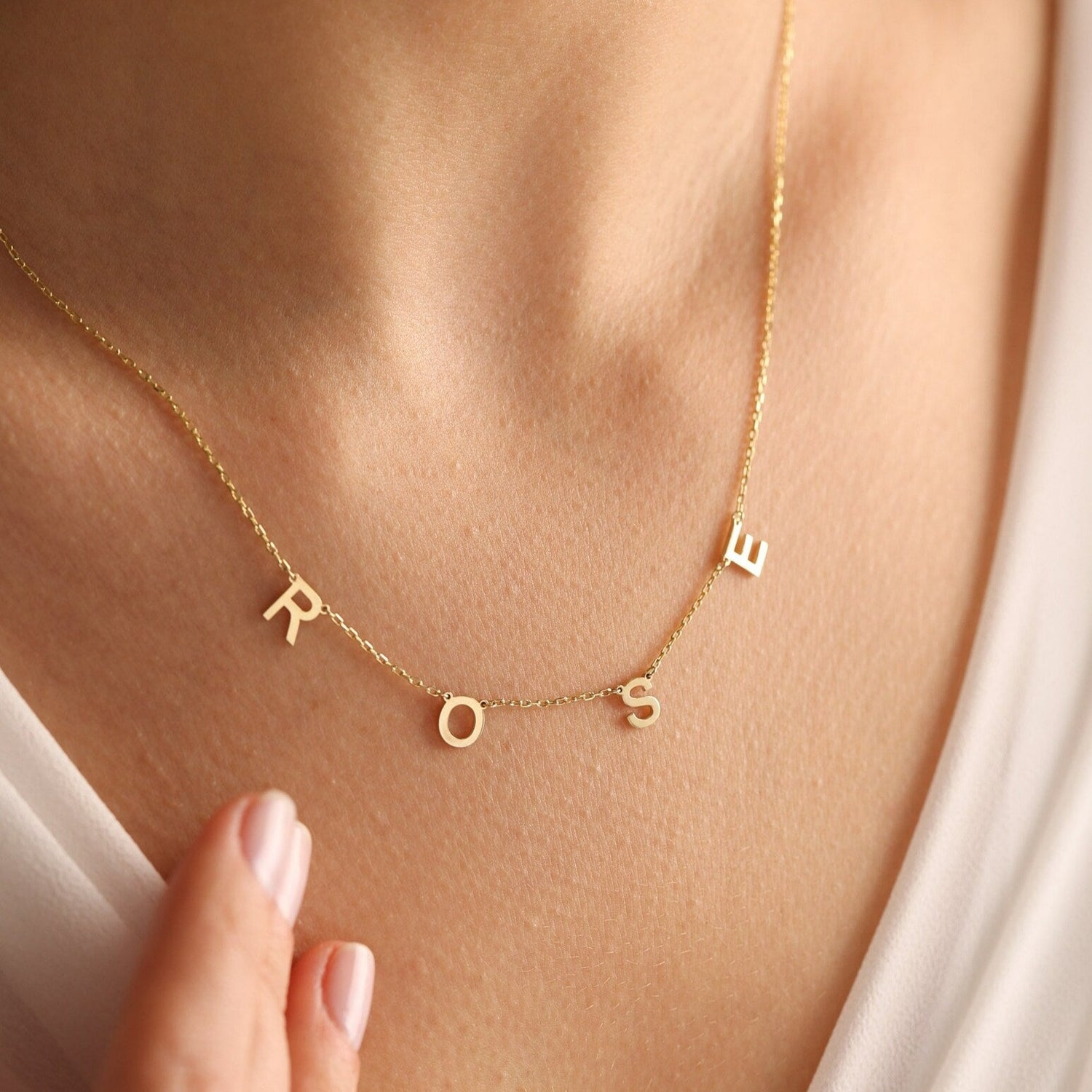 This gorgeous modern gold name necklace is handcrafted in real genuine gold by our skilled jewelers in Dubai. A truly lovely gift. Your loved one's name in gold, creating a uniquely, personal gift. Perfect addition to your jewelry collection or a gift to remember. Designed in the United Arab Emirates.