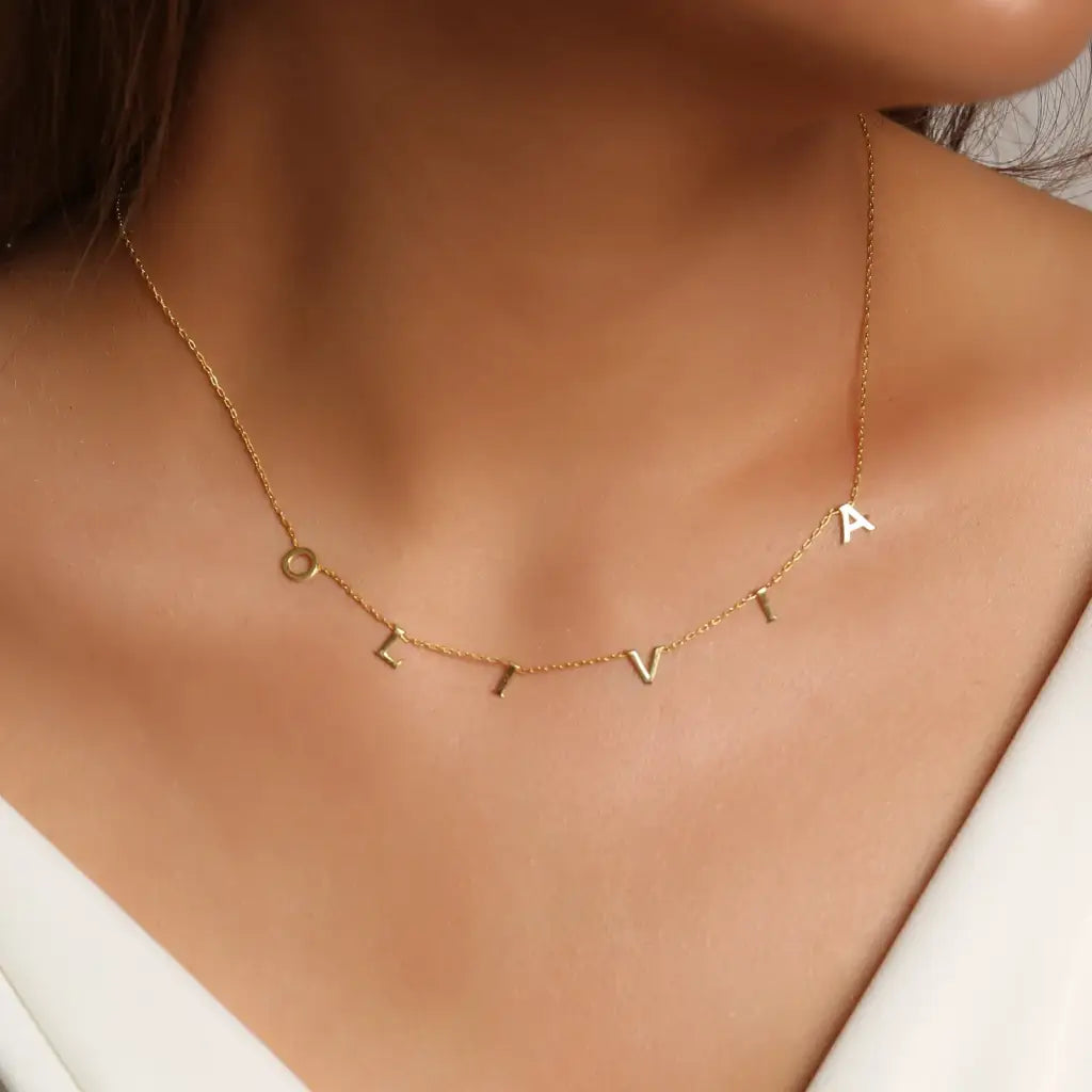 This gorgeous modern gold name necklace is handcrafted in real genuine gold by our skilled jewelers in Dubai. A truly lovely gift. Your loved one's name in gold, creating a uniquely, personal gift. Perfect addition to your jewelry collection or a gift to remember. Designed in the United Arab Emirates.