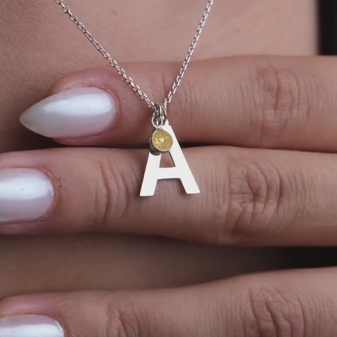 A symbol of love, this elegant 18 carat gold initial birthstone necklace features a delicate gemstone and a personalized letter pendant, making it a thoughtful present for your loved one.  Whether she's your girlfriend, fiancée, wife, sister, or mother, this necklace adds a touch of sophistication and exclusivity to any outfit and is the perfect gift to show that special woman in your life how much she means to you.