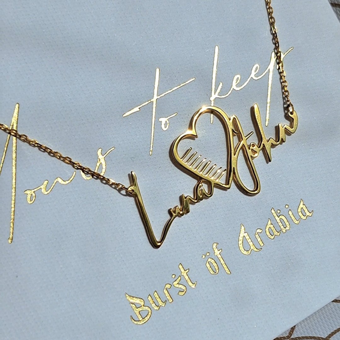 Couple name necklace designed and custom made in the UAE in 18 carat gold.