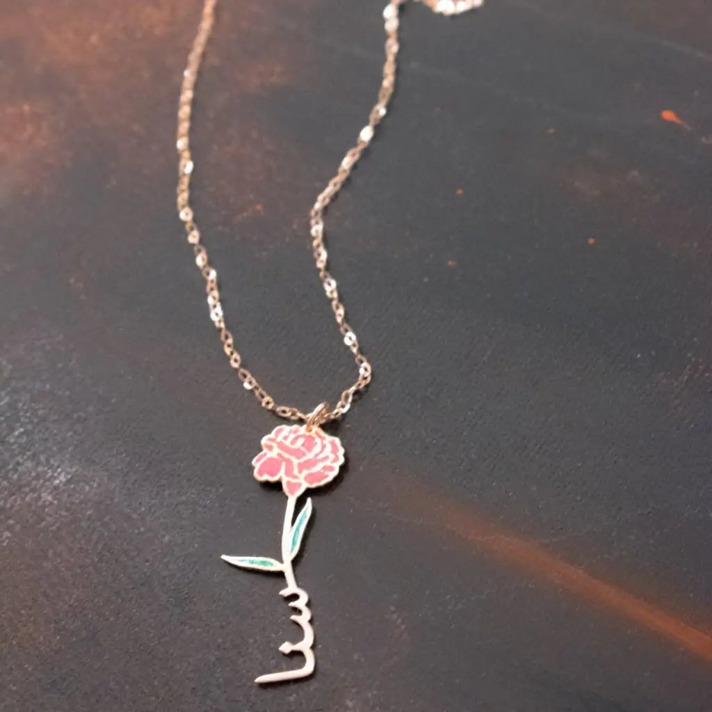 Gold Birth Flower Name Necklace made in real gold. Designed and handcrafted in the UAE. This gold birth flower Arabic name pendant is locally handcrafted with the highest quality materials and artisans available in Dubai.
