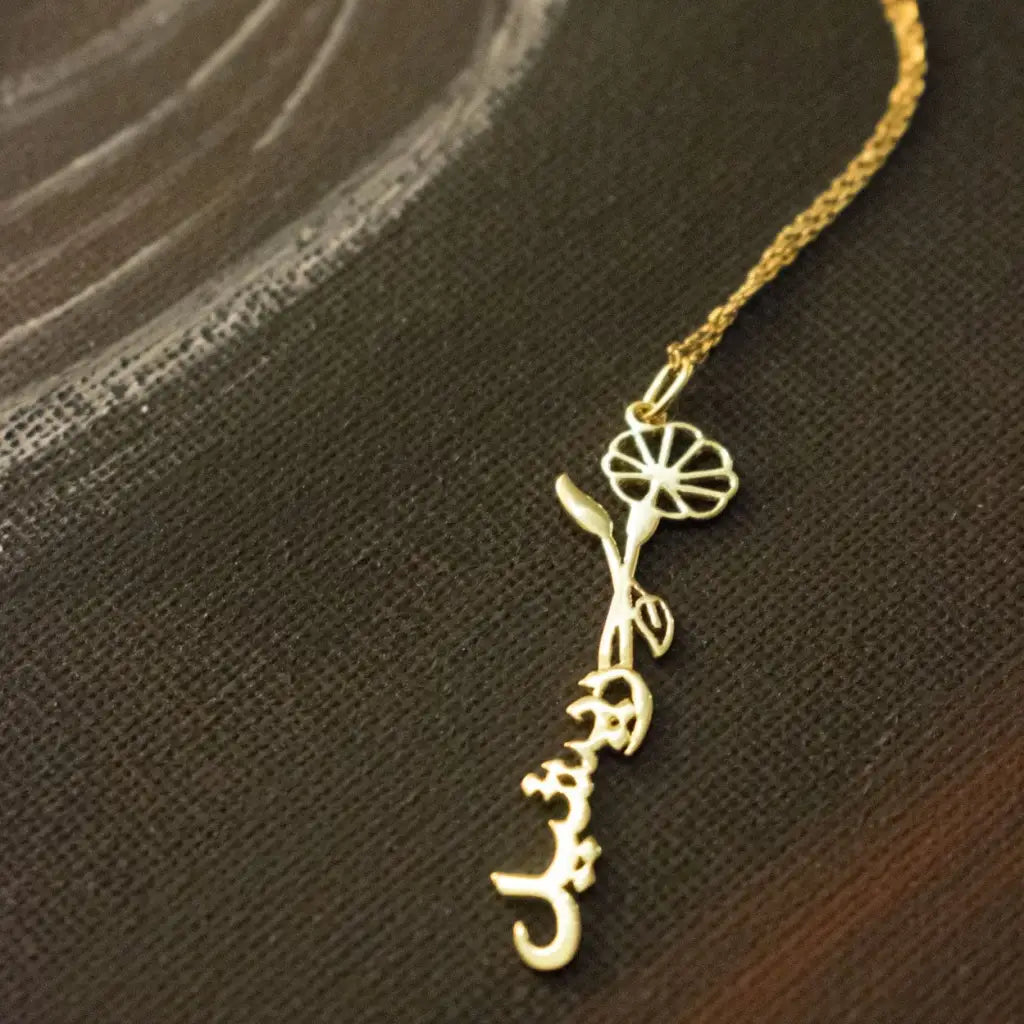 Gold Birth Flower Name Necklace made in real gold. Designed and handcrafted in the UAE. This gold birth flower Arabic name pendant is locally handcrafted with the highest quality materials and artisans available in Dubai.