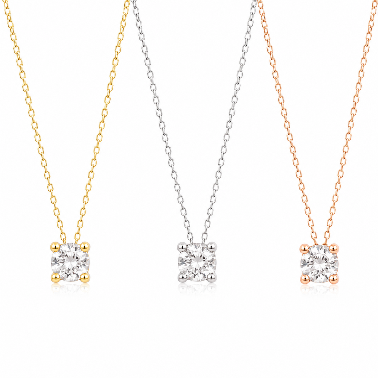 Three solitaire diamond pendant necklaces on delicate chains, shown in yellow gold, silver, and rose gold tones against a clean white background.