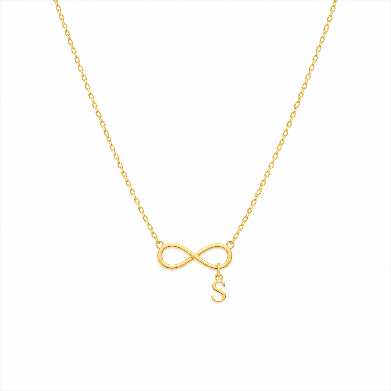 A delicate gold chain necklace featuring an infinity symbol pendant with a small hanging letter 'S' charm, shown against a plain white background.