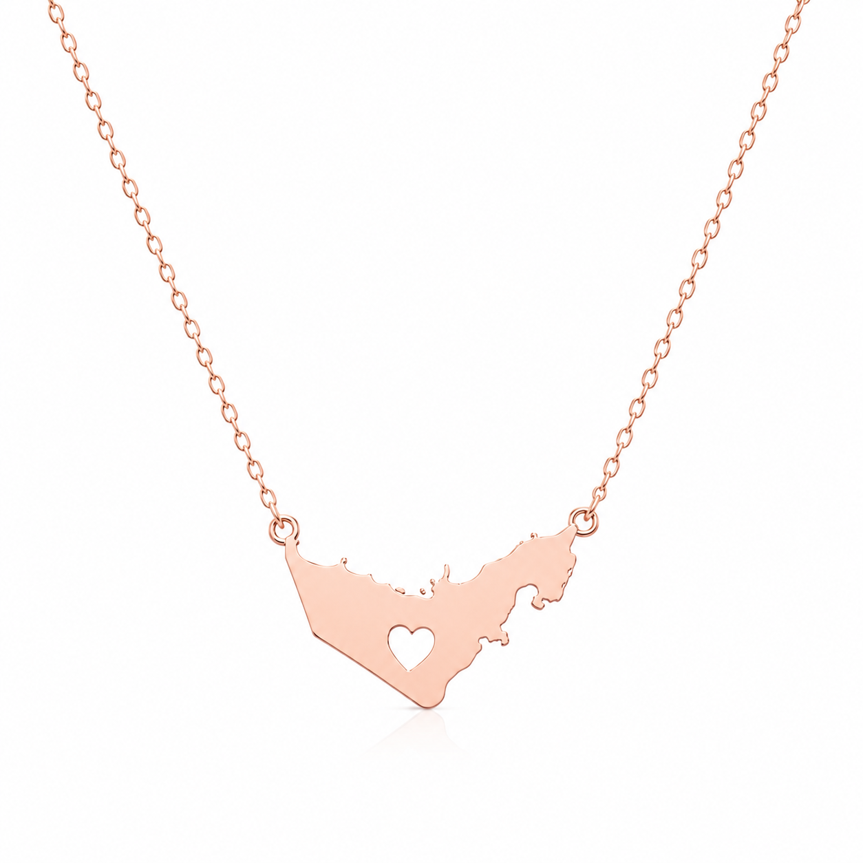 A rose gold necklace featuring a pendant shaped like the outline of United Arab Emirates with a small heart cutout in the center, displayed on a clean white background.