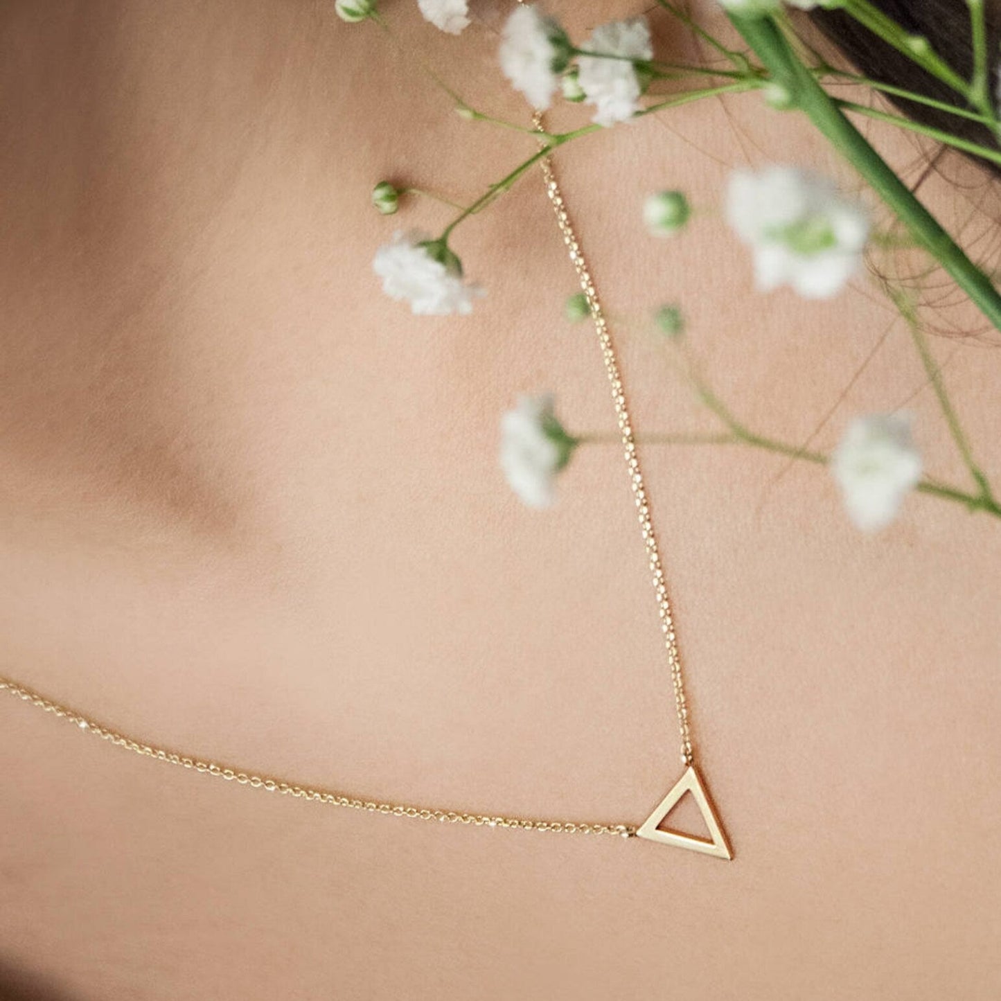 Enhance your style with the 18 Carat Gold Triangle Necklace from Burst of Arabia. A modern statement piece inspired by the timeless allure of Arabic jewelry, crafted for elegance in the UAE.