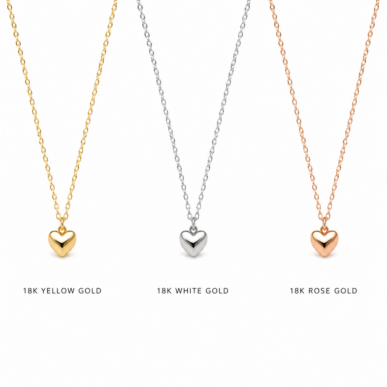 Three heart-shaped pendant necklaces displayed side by side on a white background, labeled 18K Yellow Gold, 18K White Gold, and 18K Rose Gold. The necklaces feature small polished heart pendants on delicate chains.