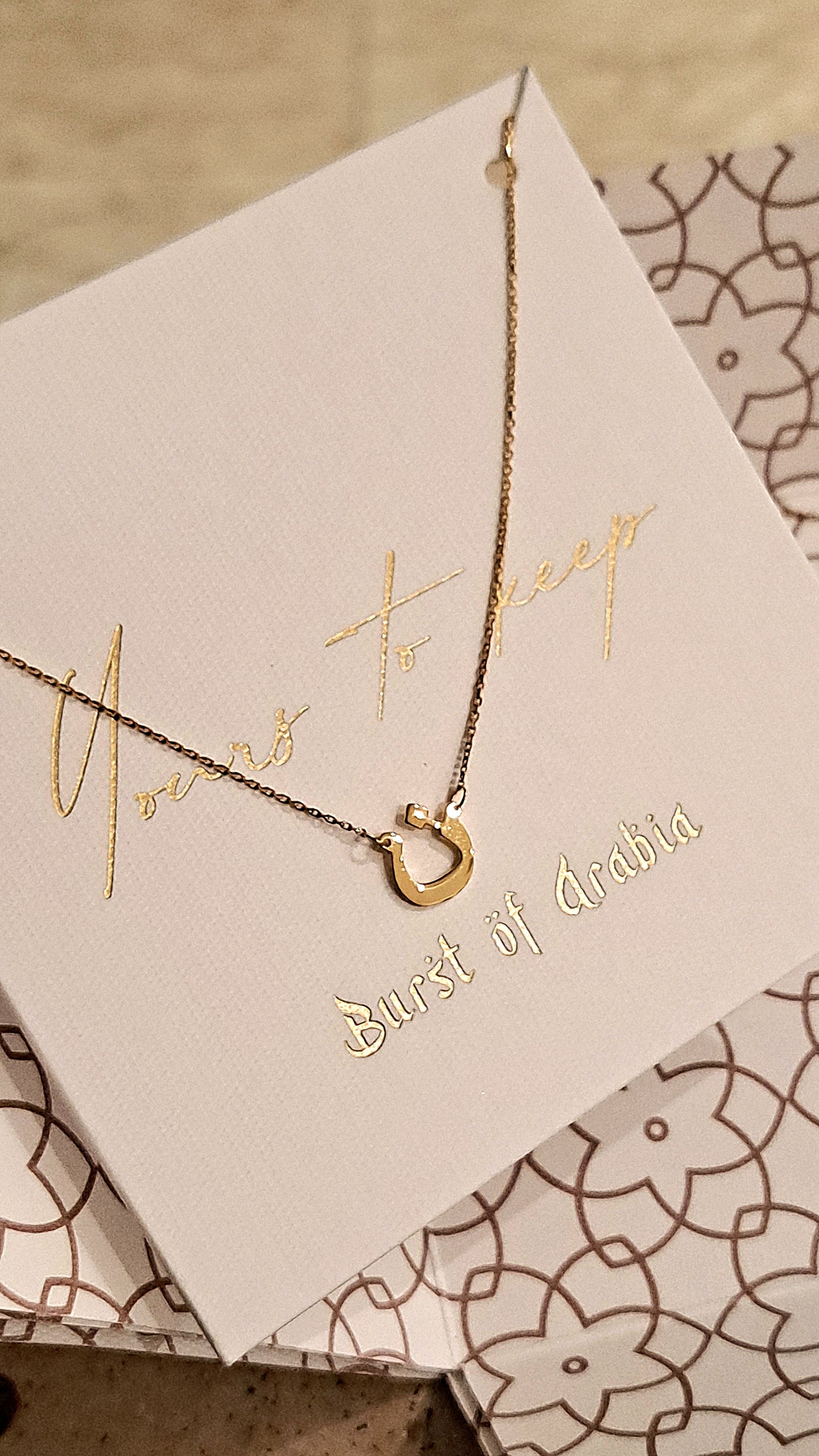 Arabic letter necklace designed in 18 carat gold.