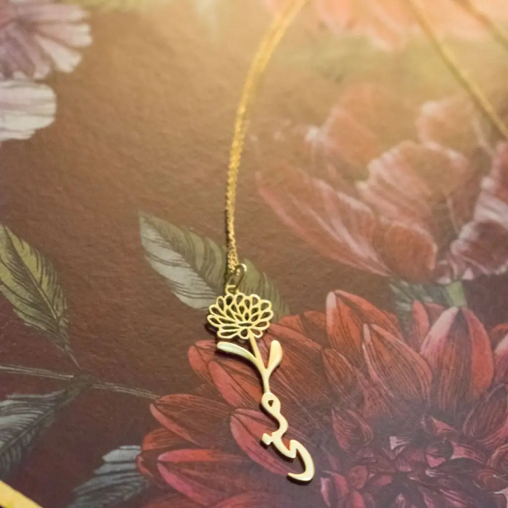 Gold Birth Flower Name Necklace made in real gold. Designed and handcrafted in the UAE. This gold birth flower Arabic name pendant is locally handcrafted with the highest quality materials and artisans available in Dubai.